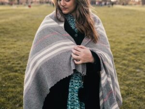 Frau mit Wolldecke auf Rasen